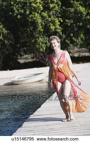 Mature woman walking on a jetty View Large Photo Image Stock Photography - Mature woman walking on a jetty. Fotosearch