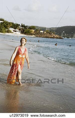 Mature woman walking on the beach View Large Photo Image Stock Photo - Mature woman walking on the beach. Fotosearch