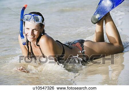 Mid adult woman wearing snorkeling gear and lying on the beach View Large Photo Image Stock Photograph - Mid adult woman wearing snorkeling gear and lying on the beach. Fotosearch
