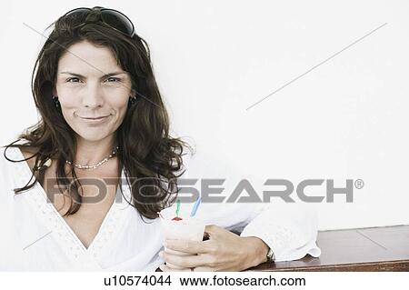 Portrait of a mid adult woman holding an ice-cream cup View Large Photo Image Picture - Portrait of a mid adult woman holding an ice-cream cup. Fotosearch