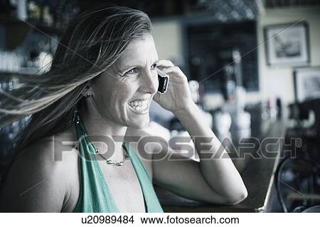 Side profile of a mid adult woman talking on a mobile phone View Large Photo Image Picture - Side profile of a mid adult woman talking on a mobile phone. Fotosearch