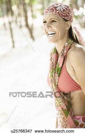 Side profile of a mid adult woman standing on the beach and smiling View Large Photo Image Stock Photo - Side profile of a mid adult woman standing on the beach and smiling. Fotosearch