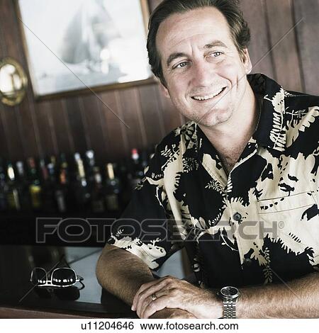 Close-up of a mid adult man sitting in a restaurant View Large Photo Image Stock Photograph - Close-up of a mid adult man sitting in a restaurant. Fotosearch