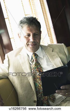 Close-up of a senior man holding a menu View Large Photo Image Stock Photograph - Close-up of a senior man holding a menu. Fotosearch
