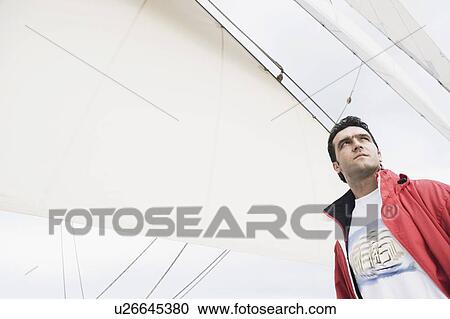 Stock Image - Low angle view of a young man. Fotosearch