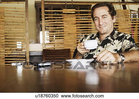 Stock Image - Portrait of a mid adult man drinking a cup of coffee. Fotosearch