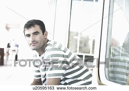 Stock Image - Portrait of a mid adult man on a sailing ship. Fotosearch
