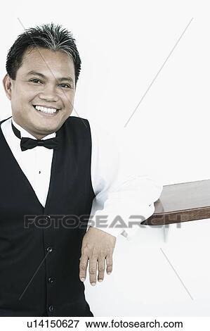 Portrait of a waiter smiling View Large Photo Image Stock Photo - Portrait of a waiter smiling. Fotosearch