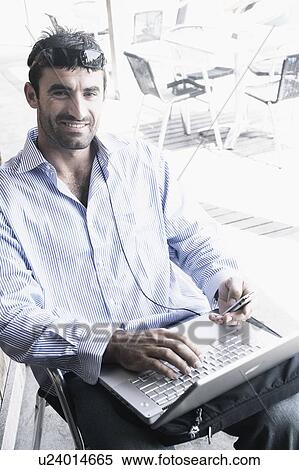 Stock Photography - Portrait of a young man using a laptop. Fotosearch
