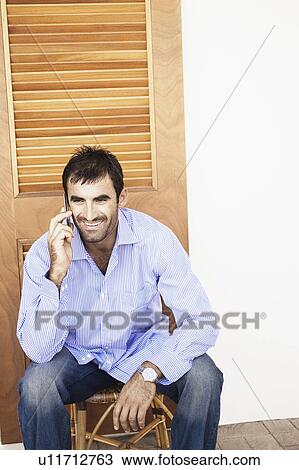 Stock Image - Young man talking on a mobile phone. Fotosearch