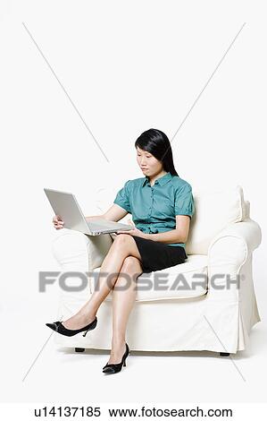 Businesswoman sitting and using a laptop View Large Photo Image Stock Photography - Businesswoman sitting and using a laptop. Fotosearch