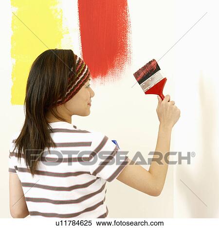 Rear view of a young woman painting the wall with a paintbrush View Large Photo Image Stock Photography - Rear view of a young woman painting the wall with a paintbrush. Fotosearch