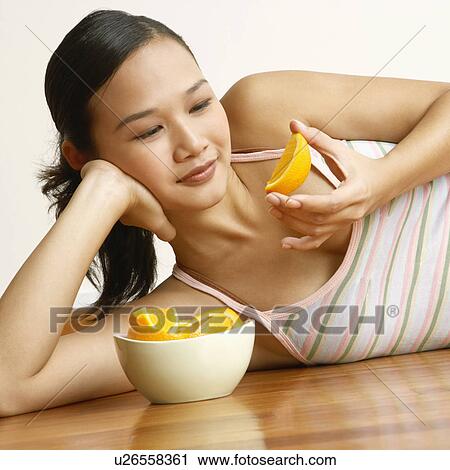 Young woman lying on the floor and holding a slice of orange View Large Photo Image Stock Image - Young woman lying on the floor and holding a slice of orange. Fotosearch