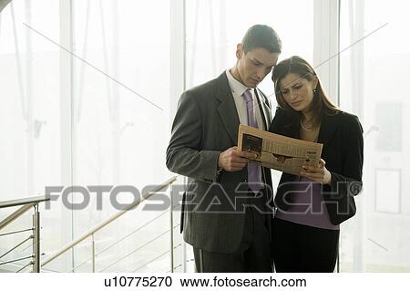 Businessman and businesswoman looking at financial newspaper View Large Photo Image Stock Image - Businessman and businesswoman looking at financial newspaper. Fotosearch
