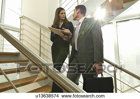 Businessman and businesswoman on staircase arguing over document View Large Photo Image Picture - Businessman and businesswoman on staircase arguing over document. Fotosearch
