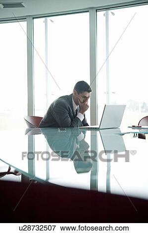 Businessman at laptop computer with his face in his hand View Large Photo Image Stock Photo - Businessman at laptop computer with his face in his hand. Fotosearch
