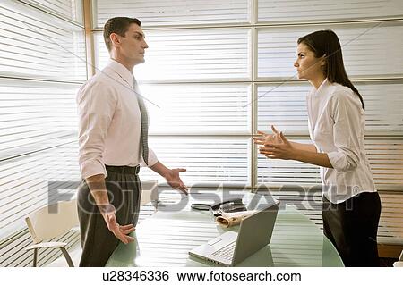 Businessman in office talking to businesswoman View Large Photo Image Stock Photograph - Businessman in office talking to businesswoman. Fotosearch