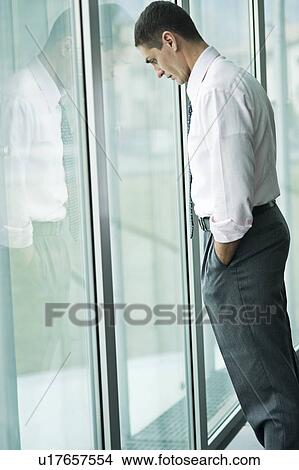 "Businessman looking out the window, hand in pocket" View Large Photo Image Picture - "Businessman looking out the window, hand in pocket". Fotosearch