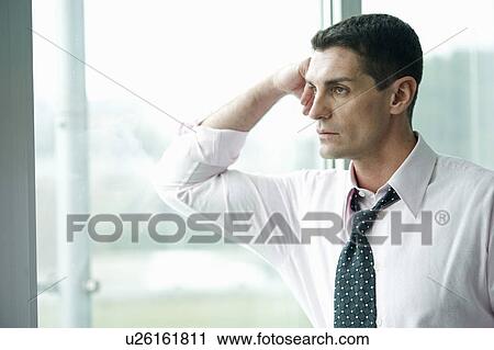 Businessman looking out the window View Large Photo Image Stock Image - Businessman looking out the window. Fotosearch