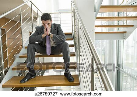 Businessman on office staircase with face in hands View Large Photo Image Stock Photo - Businessman on office staircase with face in hands. Fotosearch