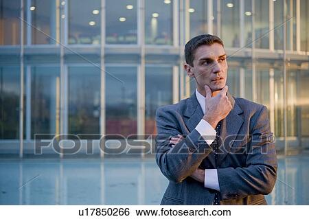 Businessman outside of office building View Large Photo Image Stock Photograph - Businessman outside of office building. Fotosearch