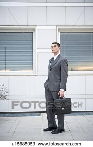 Businessman outside office building View Large Photo Image Stock Photo - Businessman outside office building. Fotosearch