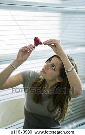 Stock Image - Professional woman looking at empty purse. Fotosearch