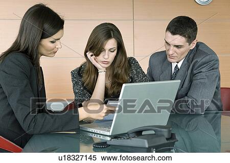 Professional woman looking over paper with couple View Large Photo Image Stock Photography - Professional woman looking over paper with couple. Fotosearch