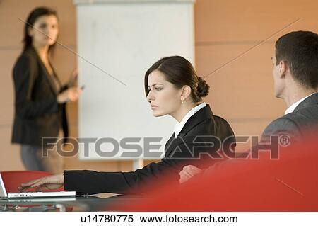Stock Photography - Businessman and woman at a presentation. Fotosearch