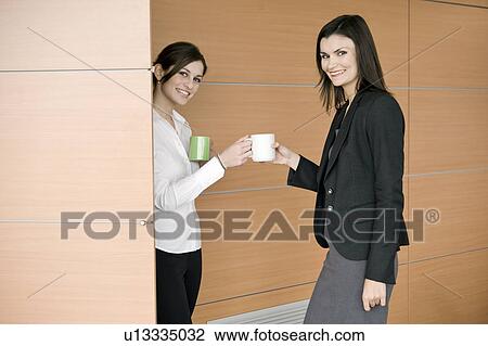 Businesswoman bringing coffee to another businesswoman View Large Photo Image Stock Image - Businesswoman bringing coffee to another businesswoman. Fotosearch