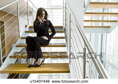 Businesswoman talking on cell phone on office staircase View Large Photo Image Stock Photo - Businesswoman talking on cell phone on office staircase. Fotosearch