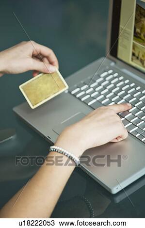Businesswoman's hands holding credit card at laptop View Large Photo Image Stock Image - Businesswoman's hands holding credit card at laptop. Fotosearch