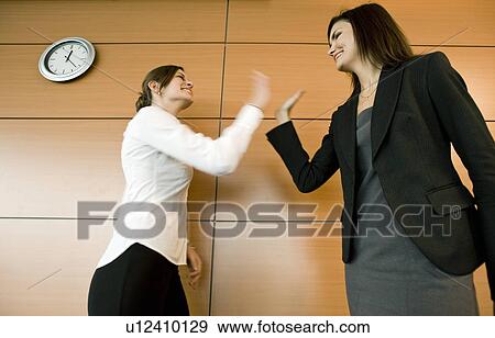 Businesswomen doing high five View Large Photo Image Stock Photo - Businesswomen doing high five. Fotosearch