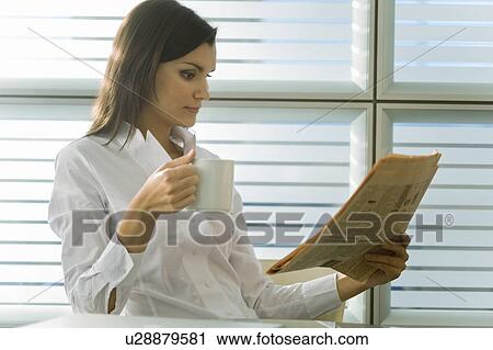 Professional woman reading newspaper and drinking coffee View Large Photo Image Stock Image - Professional woman reading newspaper and drinking coffee. Fotosearch