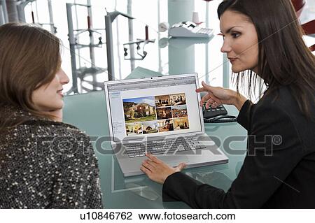 Stock Image - Two women at laptop computer. Fotosearch