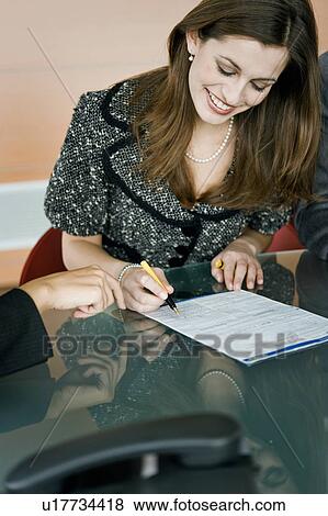 Stock Photo - "Young woman signing document, female hand pointing". Fotosearch