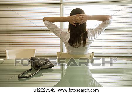 Back view of businesswoman in office with hands behind head View Large Photo Image Stock Photography - Back view of businesswoman in office with hands behind head. Fotosearch