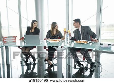Business people eating pizza and toasting at desk View Large Photo Image Stock Photography - Business people eating pizza and toasting at desk. Fotosearch