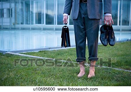 Businessman from waist down barefoot on grass outside of office building View Large Photo Image Stock Image - Businessman from waist down barefoot on grass outside of office building. Fotosearch