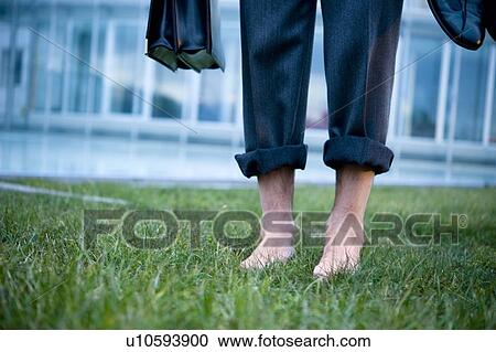 Businessman's bare feet on grass outside of office building View Large Photo Image Stock Image - Businessman's bare feet on grass outside of office building. Fotosearch