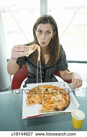Businesswoman eating pizza at desk View Large Photo Image Stock Photo - Businesswoman eating pizza at desk. Fotosearch