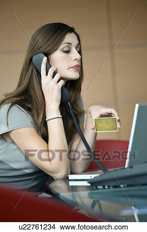 Businesswoman holding credit card at laptop View Large Photo Image Picture - Businesswoman holding credit card at laptop. Fotosearch