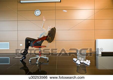 Businesswoman throwing paper into basket View Large Photo Image Stock Photograph - Businesswoman throwing paper into basket. Fotosearch