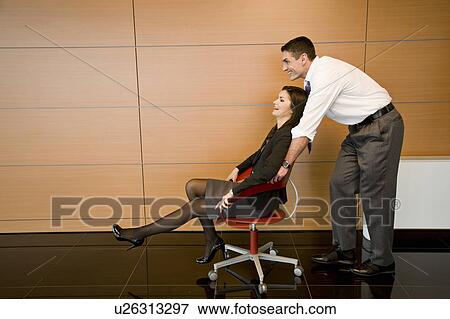 Office worker pushing coworker in office chair View Large Photo Image Stock Photo - Office worker pushing coworker in office chair. Fotosearch