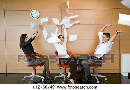 Stock Photo - Office workers throwing documents up in the air. Fotosearch