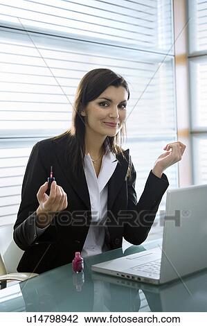 Professional woman with nail polish at desk with laptop View Large Photo Image Stock Image - Professional woman with nail polish at desk with laptop. Fotosearch