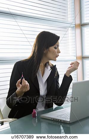 Professional woman with nail polish at desk with laptop View Large Photo Image Stock Photo - Professional woman with nail polish at desk with laptop. Fotosearch
