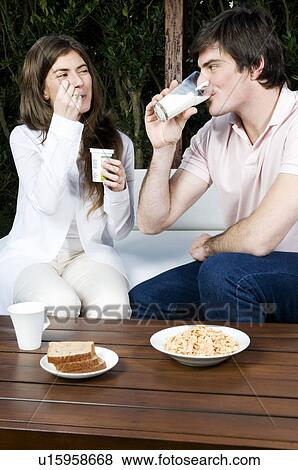 Stock Photo - Young couple having breakfast outdoors. Fotosearch