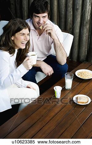 Stock Photography - Young couple having breakfast outdoors. Fotosearch