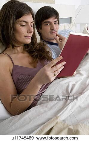 Young couple in bed relaxing View Large Photo Image Stock Photo - Young couple in bed relaxing. Fotosearch